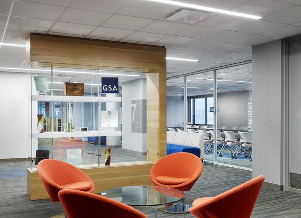 Image of GSA open collaborative workspace with four orange chairs surrounding a table.