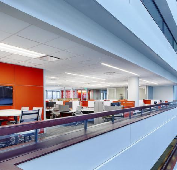 GSA office hallway with orange walls and white desks.